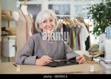Woman dressmaker makes pattern using tablet Stock Photo