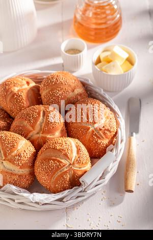Homemade Kaiser buns with sesame , freshly baked. Breakfast with rolls, honey and butter. Stock Photo