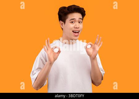 Happy asian young man gesturing okay and smiling Stock Photo
