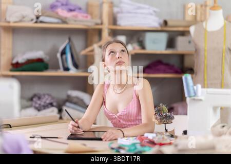 Woman dressmaker makes pattern using tablet Stock Photo