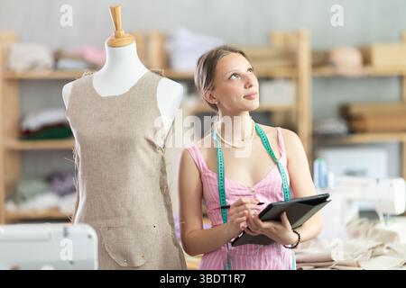 Woman dressmaker makes pattern using tablet Stock Photo