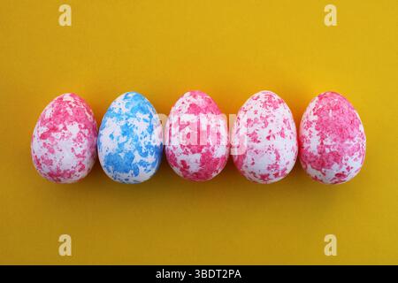 Spotted egg trapped among other eggs of a different color Stock Photo