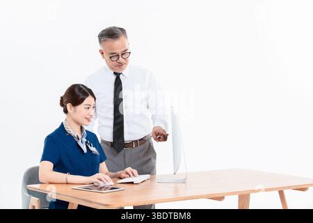 A business elderly man and a young woman standing (sitting) at the office desk Stock Photo