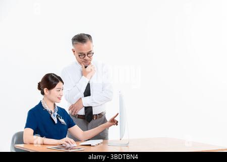 A business elderly man and a young woman standing (sitting) at the office desk Stock Photo