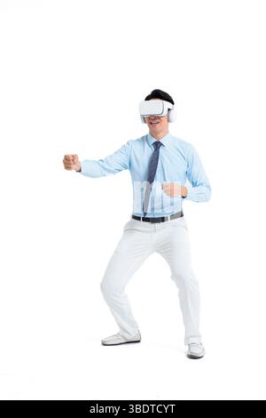 A suited man wearing a VR headset waves both hands vigorously Stock Photo