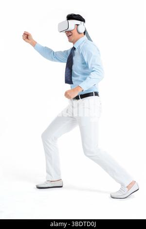 A suited man wearing a VR headset waves both hands vigorously Stock Photo