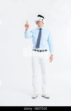 A suited man wearing a VR headset waves both hands vigorously Stock Photo