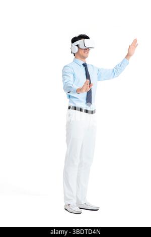 A suited man wearing a VR headset waves both hands vigorously Stock Photo
