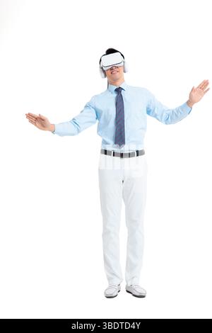 A suited man wearing a VR headset waves both hands vigorously Stock Photo