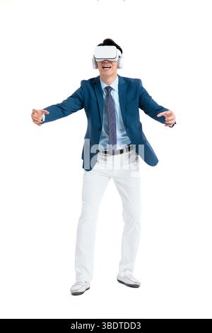 A suited businessman interacts with virtual objects through frenzied gestures, wearing VR/AR headset Stock Photo