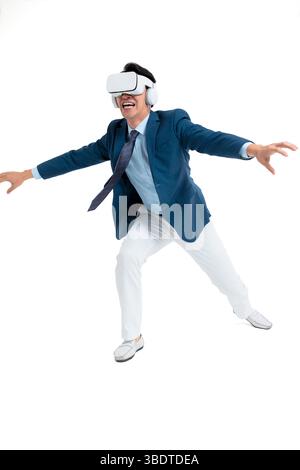A suited businessman interacts with virtual objects through frenzied gestures, wearing VR/AR headset Stock Photo