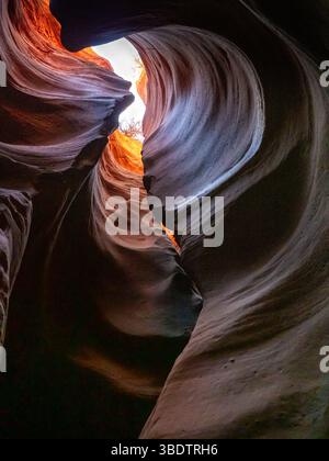 Sculpted sandstone walls inside a hidden slot cave near Orderville, Arizona, USA, with glowing light and abstract rock formations Stock Photo