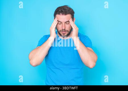 Headache migraine concept. Tired man suffering from headache, exhausted with closed eyes touching head. Closeup man touching temples with fingers from Stock Photo