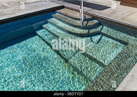 Steps leading gently into a shallow pool with rippled patterns on the water Stock Photo