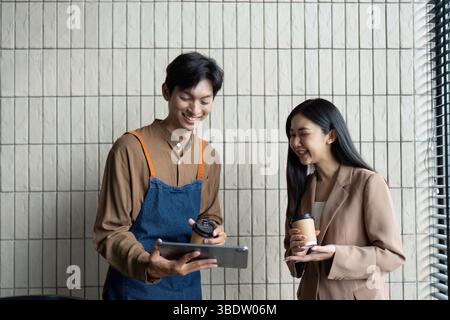 Engaging Team Meeting. Two colleagues sharing insights and discussing ideas over coffee and a tablet. Stock Photo