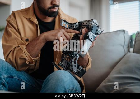 Handsome engineer student working on robot project at home. Stock Photo