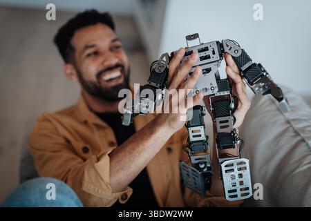 Handsome engineer student working on robot project at home. Stock Photo