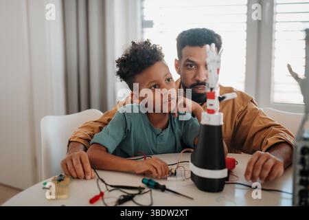 Father and son working on robotic car together. STEM concept. Stock Photo
