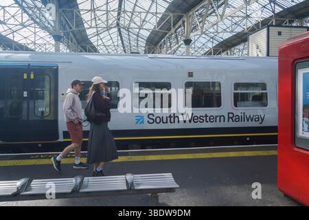 London, UK. 26  May 2025.  Passengers walk past a South Western Railway train on a platform at  Waterloo station South Western Railway becomes  the first railway franchise to be  go into public ownership and be re-nationalised  under the Great British Railways brand  as part of the Labour general election manifesto  Credit Amer Ghazzal/Alamy Live News Stock Photo
