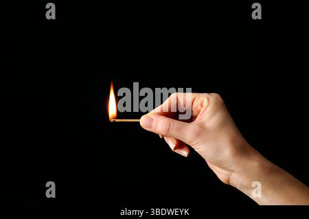 Lit match against a black background Stock Photo