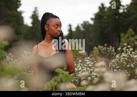Young woman standing in a field of flowers Stock Photo