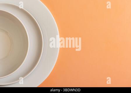 Culinary Minimalism: Composition of White Plates on Salmon Background Stock Photo