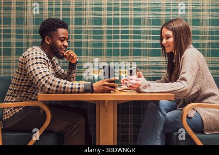 Two friends are having dinner at restaurant. They are sitting, talking and enjoying time together. Stock Photo