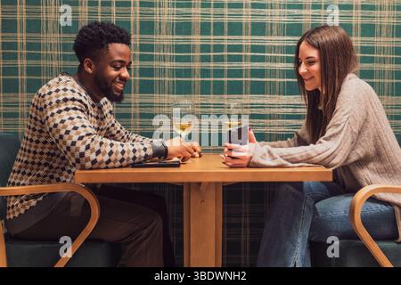 Two friends are having dinner at restaurant. They are sitting, talking and enjoying time together. Stock Photo