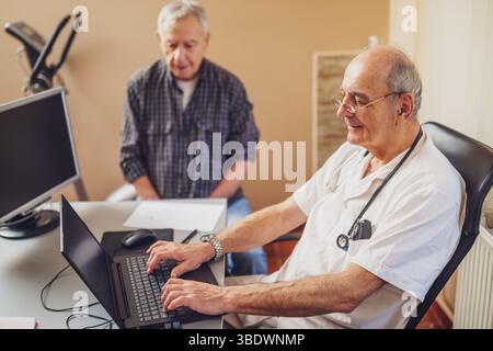 Elderly patient is having exam at cardiologist. Doctor is looking at his medical record. Stock Photo