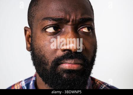 Close up portrait of worried and distraught black man. Anxious man is looking away. Stock Photo
