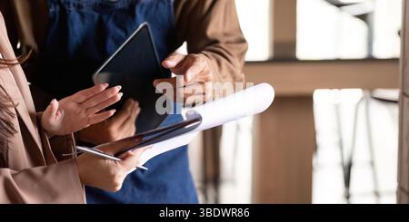 Collaborative Business Discussion. Two professionals engaging in a productive meeting over a tablet and documents. Stock Photo