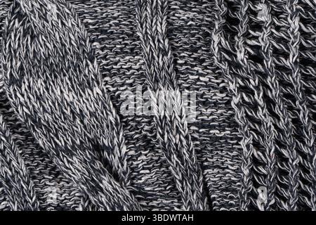Background of gray knitted dense with white and black threads. Part of knitted sweater. Stock Photo