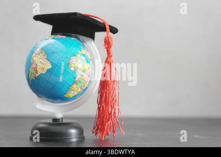 International Day of Education, study abroad and global education concept with a graduation hat on a earth globe. Stock Photo