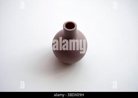 A small clay pot isolated on a white background. A tiny brown vase. Stock Photo