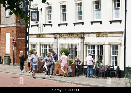 People Enjoying Casual Outdoor Dining Near a Historical Pub on a Sunny Day. Chichester, UK Stock Photo