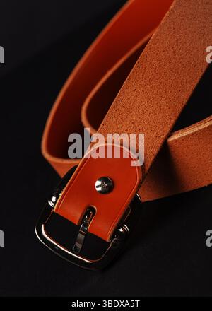 A brown belt with a silver buckle. The buckle is on the left side of the belt Stock Photo