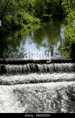 River water cascades over a small weir in Wilton, Near Salisbury, Wiltshire UK.  Copyright2024DominicParkes Stock Photo
