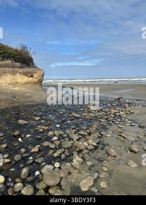 A small creek flowing into the ocean on the beach at Washburne State Park near Yachats, Oregon. Stock Photo