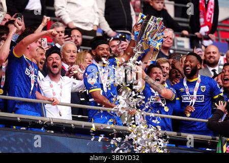 AFC Wimbledon's Ryan Johnson and Jack Reeves lift the trophy with team ...