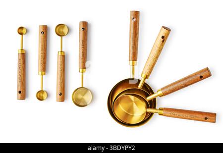Golden measuring spoons with wooden handles isolated on white background Stock Photo