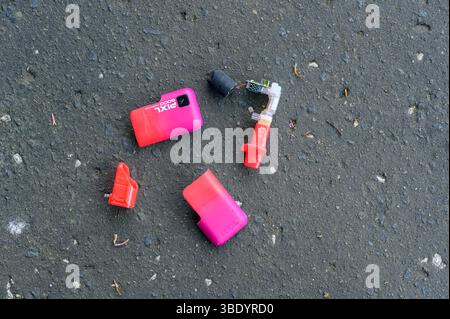 A disposable vape broken and discarded on a pavement, UK Stock Photo