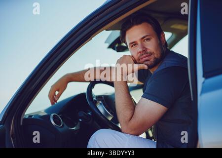 Handsome young pensive man sitting in car Stock Photo