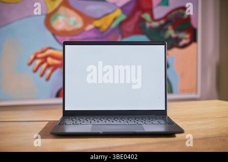 Open Laptop Displaying Blank Screen on Wooden Desk Stock Photo