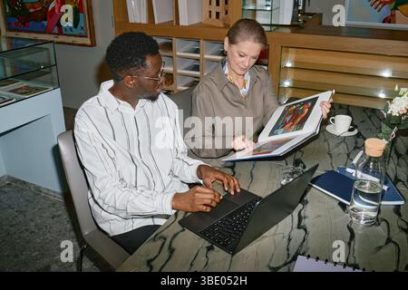 Colleagues Discussing Project While Reviewing Documents Stock Photo