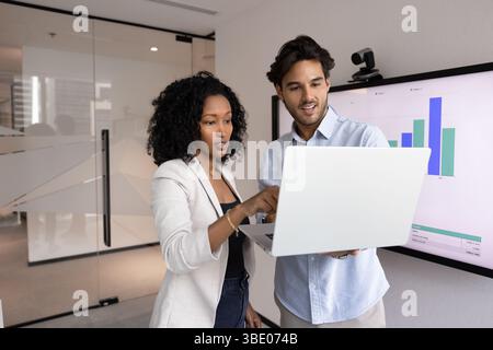 Hispanic and African teammates using modern laptop in office Stock Photo