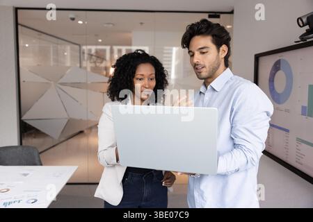 Two colleagues working in office using laptop Stock Photo