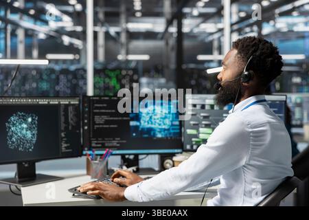 Employee talking in headset mic with technicians setting up data center equipment needed to run artificial intelligence. Server room worker in remote call with engineers installing AI tools Stock Photo