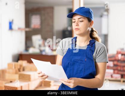 Female foreman making task list in building under construction Stock Photo