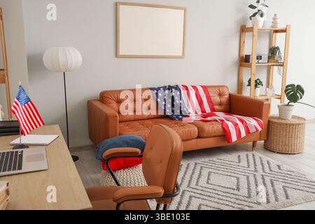 Interior of living room with USA flag on sofa, blank frame and shelf unit Stock Photo