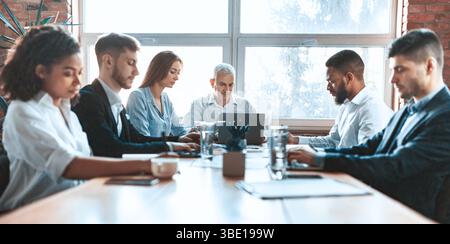 Business People Working Sitting Together At One Table In Office Stock Photo